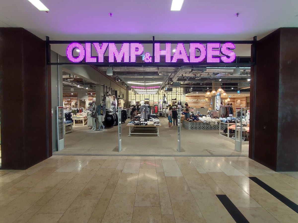 Eingang eines Olymp & Hades Geschäfts in einem Einkaufszentrum mit leuchtendem Schriftzug